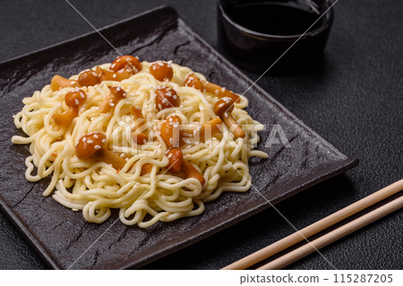 Delicious Asian cuisine dish with rice noodles, peppers, mushrooms and spices Delicious Asian cuisine dish with rice noodles, peppers, mushrooms and spices 115287205