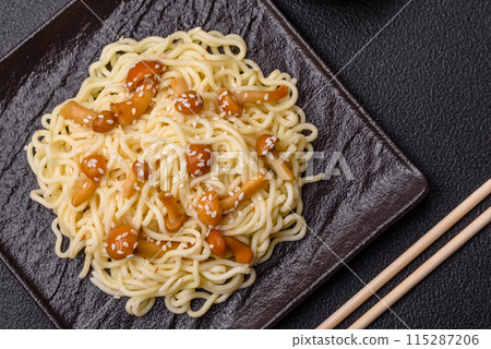 Delicious Asian cuisine dish with rice noodles, peppers, mushrooms and spices Delicious Asian cuisine dish with rice noodles, peppers, mushrooms and spices 115287206