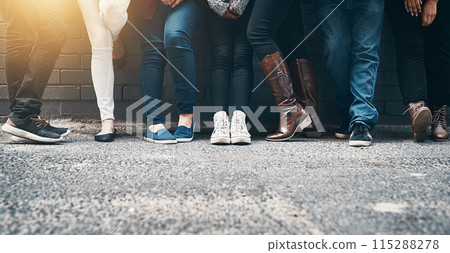 Outdoor, legs and people in row against wall while waiting, appointment and line for registration. Feet, shoes and footwear of crowd for voting outside by ground, pavement and cement in town Outdoor, legs and people in row against wall while waiting, appointment and line for registration. Feet, shoes and footwear of crowd for voting outside by ground, pavement and cement in town 115288278