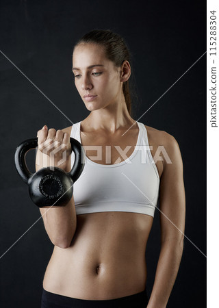 Woman, fitness and sport with kettle bell for weight lifting, strength training and exercise isolated in studio. Female person or bodybuilder and equipment for endurance workout, health and wellness 115288304