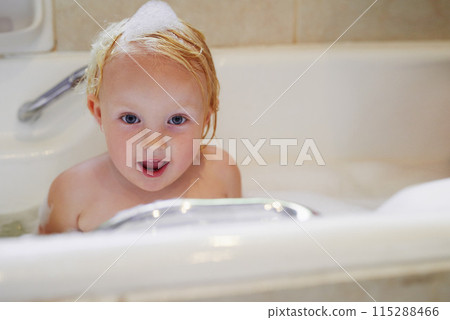 Portrait, bathtub and happy baby girl in water for hygiene, health or wellness in bathroom in Switzerland. Foam, soap and face of kid bathing, clean skin and cute toddler child with bubbles in home Portrait, bathtub and happy baby girl in water for hygiene, health or wellness in bathroom in Switzerland. Foam, soap and face of kid bathing, clean skin and cute toddler child with bubbles in home 115288466