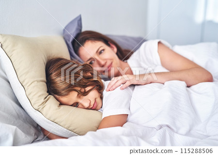 Family, single mother and daughter sleeping in bedroom for resting, comfort or bonding in home. Love, smile and woman with girl child in bed for nap, safety and security on childhood in apartment Family, single mother and daughter sleeping in bedroom for resting, comfort or bonding in home. Love, smile and woman with girl child in bed for nap, safety and security on childhood in apartment 115288506