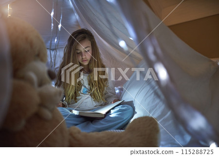 Night, girl and blanket fort for reading book, learning or education for childhood development. Home, child and fairytale with storytelling, relax or fantasy for entertainment or knowledge in house Night, girl and blanket fort for reading book, learning or education for childhood development. Home, child and fairytale with storytelling, relax or fantasy for entertainment or knowledge in house 115288725