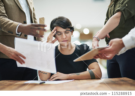 Business woman, headache and colleagues with documents for feedback, crisis or burnout in office. Female person, stress or migraine with papers in chaos for teamwork, mentorship or leadership 115288915