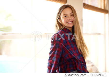 Portrait, preteen and girl in home, smile and break in weekend, relax and happiness for vacation in city. Living room, window and kid with joy for holiday, student and learner of school in New York Portrait, preteen and girl in home, smile and break in weekend, relax and happiness for vacation in city. Living room, window and kid with joy for holiday, student and learner of school in New York 115289318