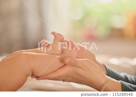 Baby, feet and hands massage in bedroom for care, love and bonding with adorable cute kid in family home nursery together. Foot, infant and child closeup on bed for development, health or parenting Baby, feet and hands massage in bedroom for care, love and bonding with adorable cute kid in family home nursery together. Foot, infant and child closeup on bed for development, health or parenting 115289548