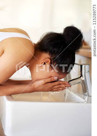 Woman, bathroom and sink in home for washing face, skincare and beauty for morning routine or wellness. Female person, tap or girl cleaning with water in house for natural facial treatment in basin 115289773