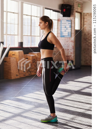 Woman, gym and stretch leg for warmup for workout with preparation for exercise or training for health. Wellness, sports and muscle with aerobics for stamina or strength with fitness in morning. 115290065
