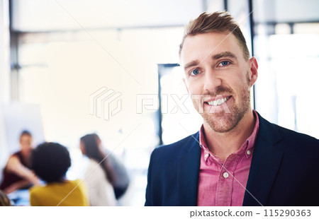 Business man, portrait and smile in office for teamwork, communication and collaboration. Male professional, happy and confident with colleagues meeting behind for planning, discussion or project 115290363