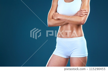 Arms crossed, body and fitness with woman on space in studio isolated on blue background closeup. Exercise, gym and health with confident sports athlete in underwear for training, wellness or workout 115290455