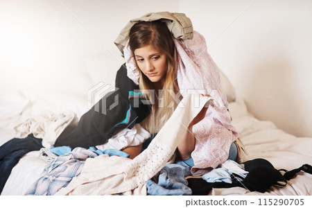 Woman, cleaning and tired of laundry in home and frustrated with dirty clothes on bed, Girl, washing and overwhelmed to start task in apartment with chaos of linen, fabric and mess in bedroom to tidy 115290705