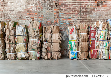 Recycled Cardboard Bales a Weathered Brick Wall 115293397