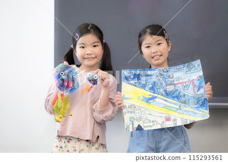 孩子們在學校展示他們的圖畫和工藝品，多人看著相機 115293561