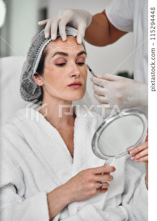 Injections into the skin of the face. A woman came to the clinic for facial skin care. Injections into the skin of the face. A woman came to the clinic for facial skin care. 115294448