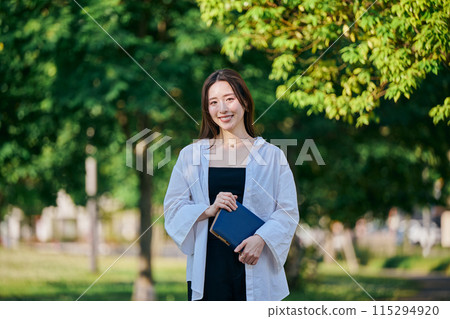 一個帶著筆記本走路的年輕女子 一個帶著筆記本走路的年輕女子 115294920