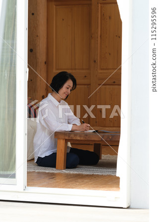 中年婦女在客廳寫信 中年婦女在客廳寫信 115295596