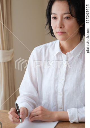 中年婦女在客廳寫信 中年婦女在客廳寫信 115295625