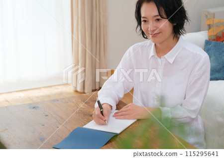 中年婦女在客廳寫信 中年婦女在客廳寫信 115295641