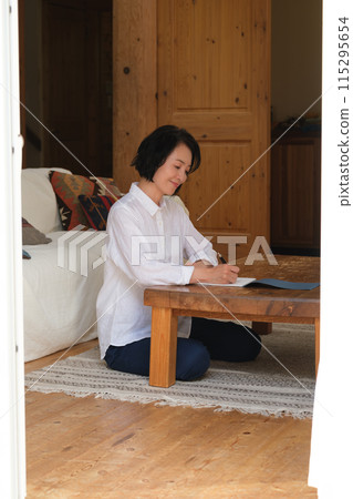 中年婦女在客廳寫信 115295654