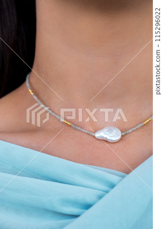Young woman wearing a pearl and aventurine necklace. Beautiful valentine's gift. 115296022