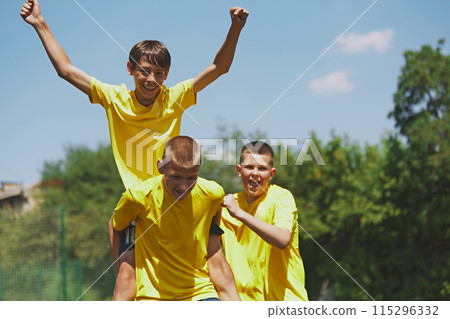 Youth Soccer Enthusiasm. Energetic boys in matching yellow sports uniform celebrating winning game. Youthful enthusiasm. 115296332
