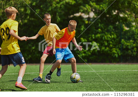 Energetic Team Play. Young athletes in uniform training, playing with focus and determination on outdoor field on sunny day. Energetic Team Play. Young athletes in uniform training, playing with focus and determination on outdoor field on sunny day. 115296381