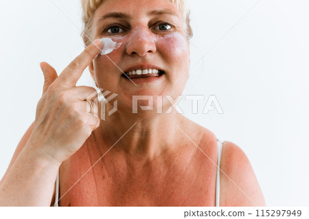 Middle-aged woman applying after-sun cream 115297949
