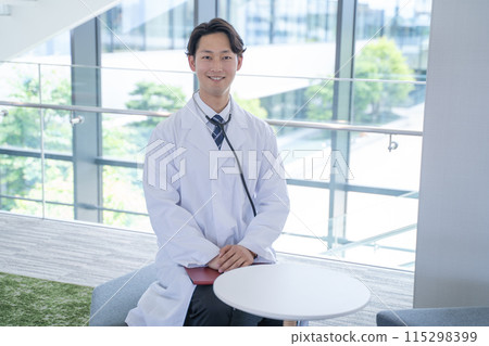 Smiling male doctor asking questions at the hospital 115298399