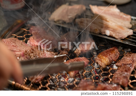 Korean Style Barbecue on stainless grill. BBQ rare meat with soft focus 115298891