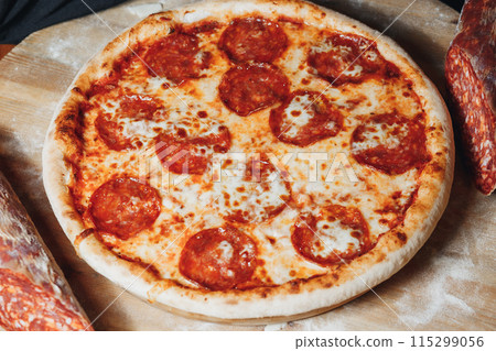 Sizzling Pepperoni Perfection,A mouthwatering pepperoni pizza sits on a rustic wooden cutting board, 115299056