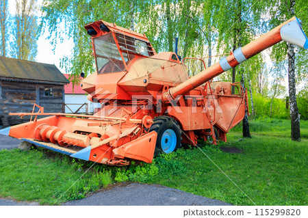 Old combine harvester in the farmyard. Old agricultural machinery Old combine harvester in the farmyard. Old agricultural machinery 115299820