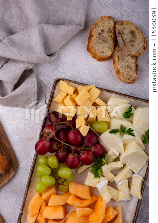 Cheese plate with different cheese, grapes and melon. Cheese plate with different cheese, grapes and melon. 115300391