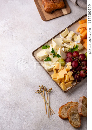 Cheese plate with different cheese, grapes and melon. 115300409