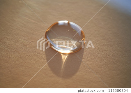 Beautiful volumetric drop of cosmetic product on a beige background. 115300804