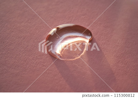 Beautiful volumetric drop of cosmetic product on a pink background. 115300812