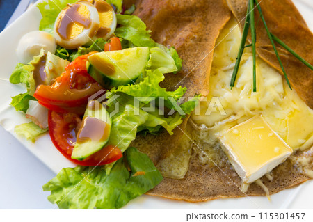 Pancake with melted cheese and salad from fresh vegetables 115301457
