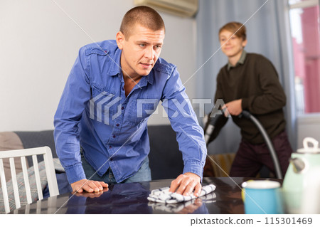 Man wipes the table at his home 115301469