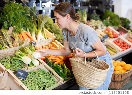 Young woman customer buying fresh fennel in grocery store Young woman customer buying fresh fennel in grocery store 115301568