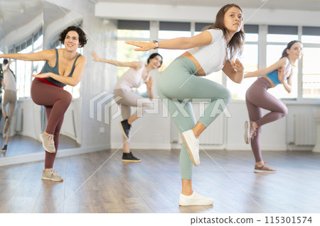 Smiling young woman enjoying vigorous dance at group class 115301574