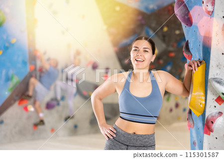 Young woman posing on climbing wall 115301587