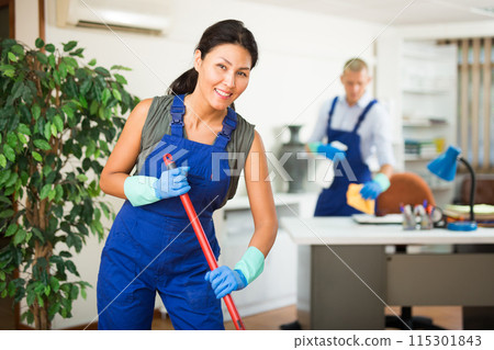 Woman wiping office floor with mop Woman wiping office floor with mop 115301843
