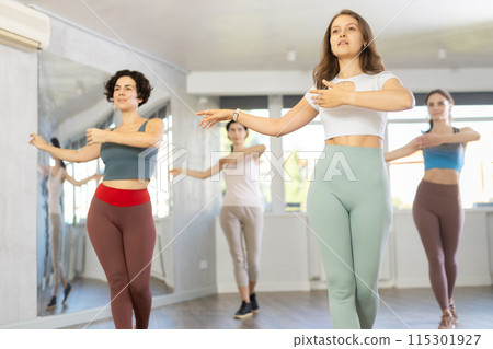 During dance lesson, girls practice and memorize movements to perform slow classical waltz dance. 115301927