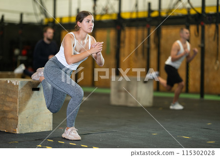 Girl performing Bulgarian split squats with plyo box during cross training 115302028