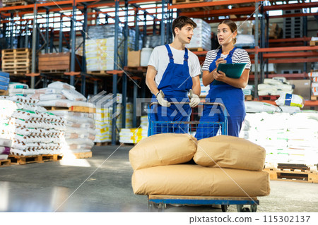 Young woman and young guy checking documents in warehouse Young woman and young guy checking documents in warehouse 115302137