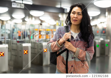 Asian woman passing through ticket gates in public transportation station 115302188