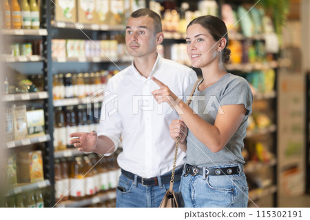 Young couple looking for fresh produce in natural foods store Young couple looking for fresh produce in natural foods store 115302191