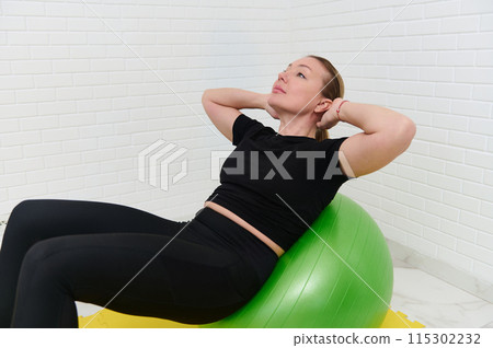 Young female athlete working out with gym equipment at home studio 115302232