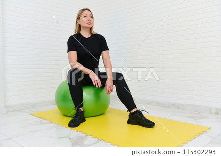 Young sporty woman working out with fitness equipment at home 115302293