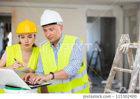 Construction workers working at house being renovated Construction workers working at house being renovated 115302400