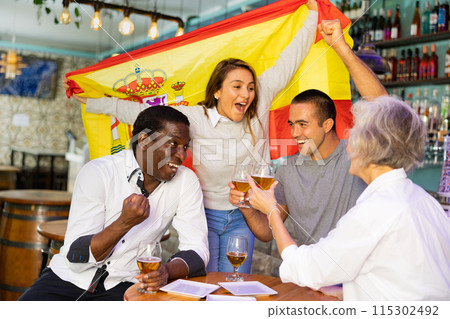 Diverse group celebrating with Spanish flag 115302492
